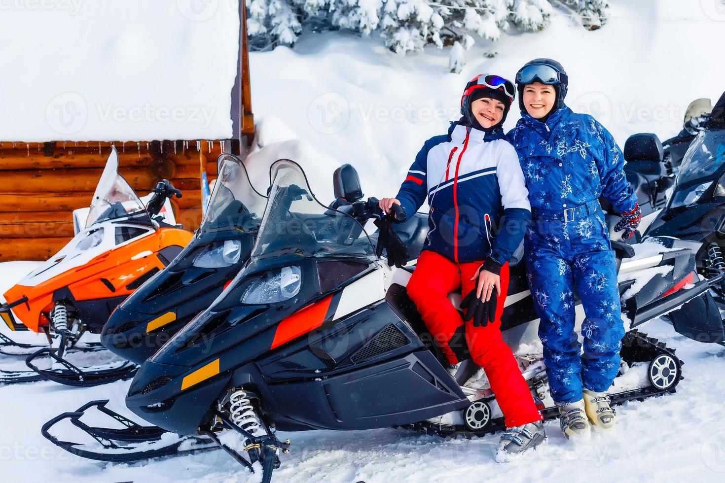 Smiling young woman riding a snowmobile photo