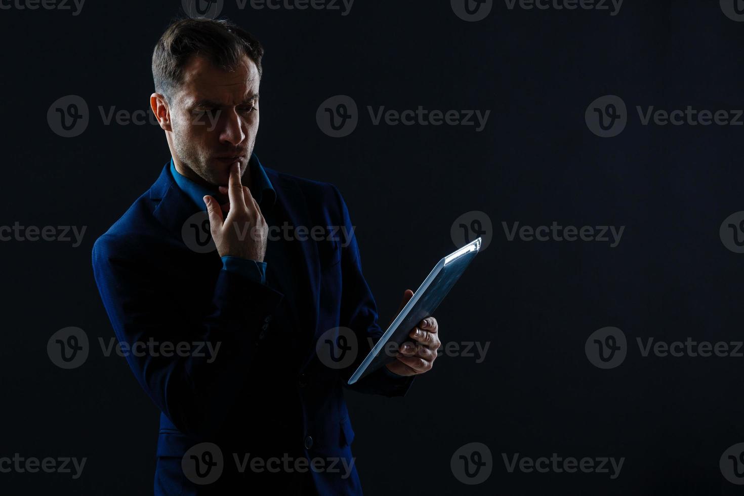 Happy smiling business man with crossed arms on black background photo