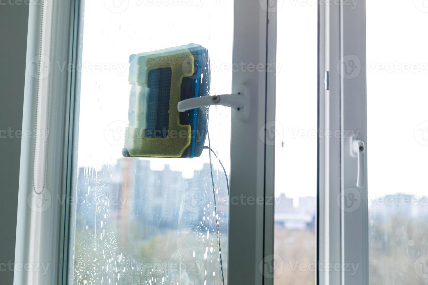 Robot window cleaner work on dirty window. Cleaning the house with smart devices. Automatic vacuum robots for cleaning windows, an assistant for the home. photo