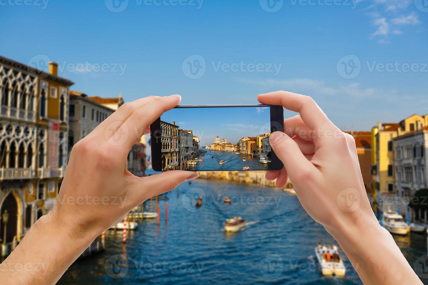 Tourist taking a picture of Grand Canal and Basilica Santa Maria della Salute in Venice, Italy photo