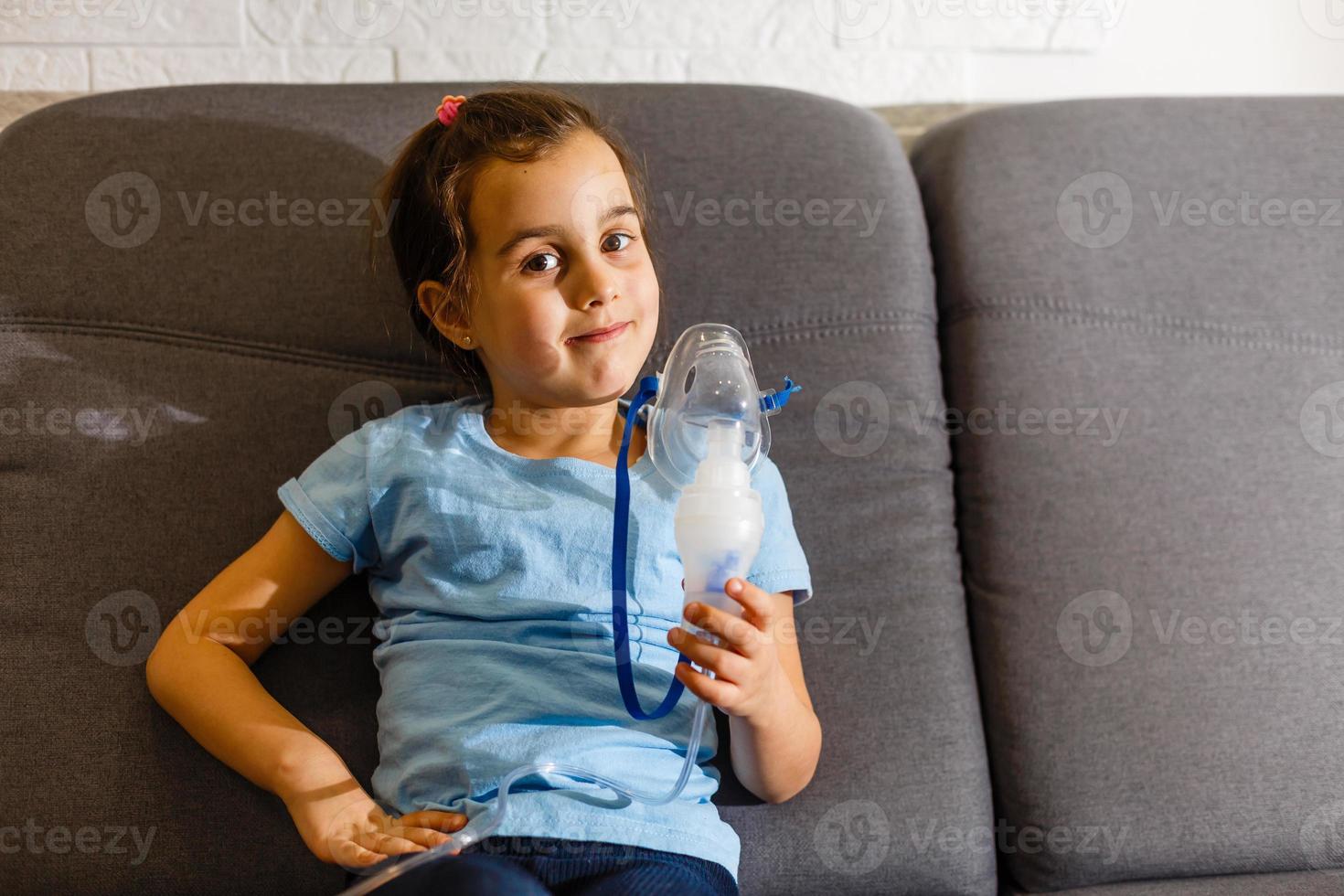 la niña caucásica respira con una máscara especial, que ayuda a detener el ataque de asma o aliviar los síntomas de la enfermedad respiratoria. foto