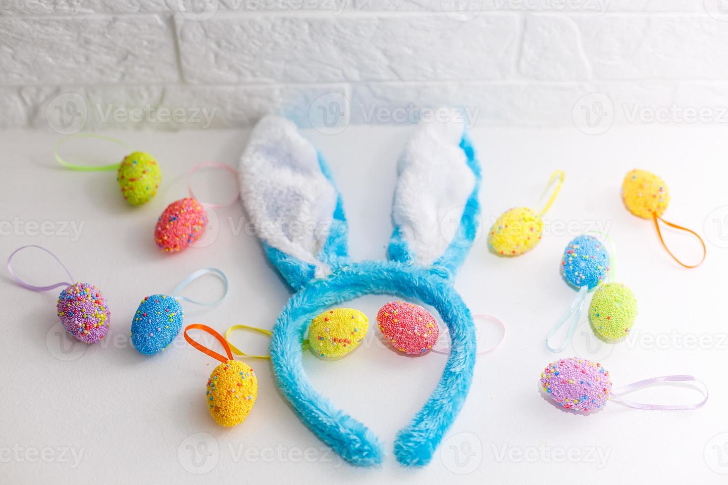 huevos de pascua de colores y orejas de conejo en casa el día de pascua. celebrando la pascua en primavera. pintando huevos foto