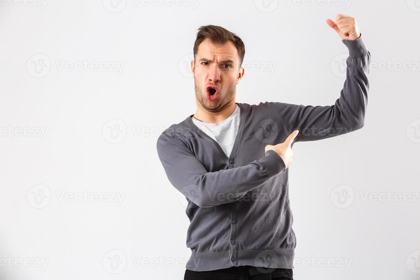 Handsome young business man over wall wearing elegant shirt showing arms muscles smiling proud. Fitness concept. photo