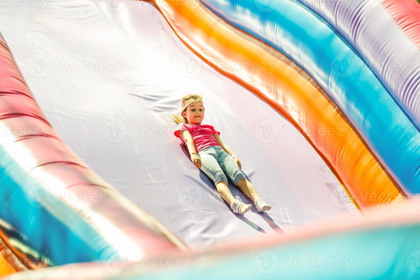 Little Girl sliding down an inflatable Slide photo