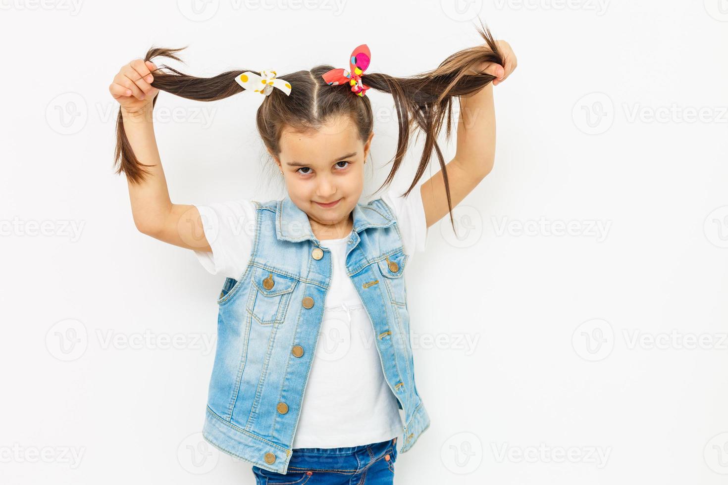 tamaño de cuerpo completo longitud de niña bonita linda alegre adorable encantadora niña pequeña con estilo con coletas rizadas en camisa de blusa formal, falda azul corta, pensando. aislado sobre fondo foto