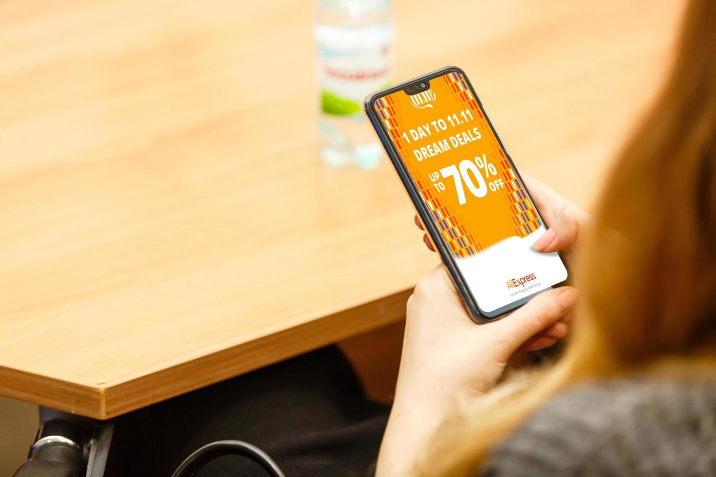 Kyiv, Ukraine - November 10, 2019 Woman holding iphone Xr with Internet shopping service Aliexpress on the screen. photo