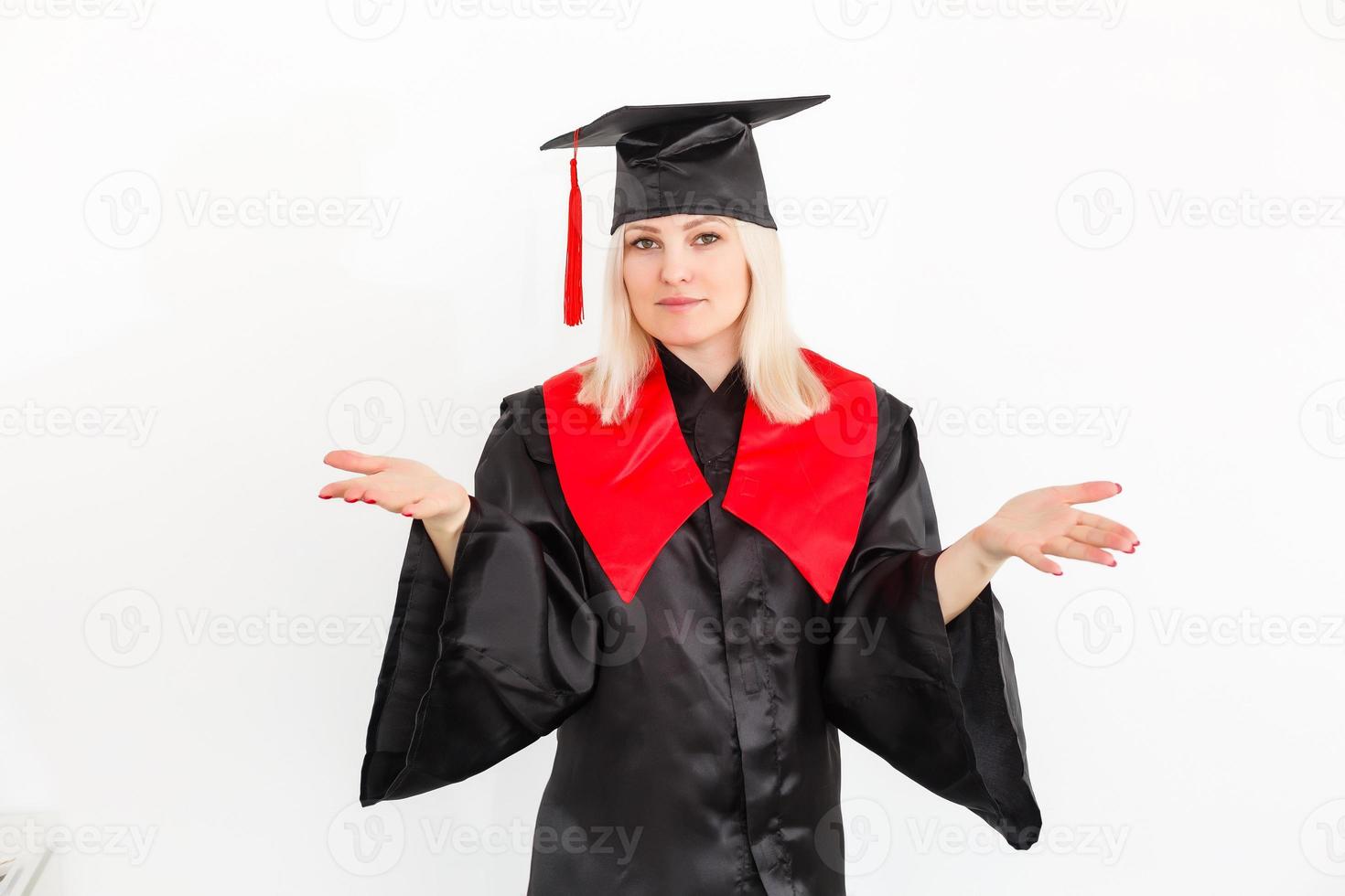 emocionada feliz estudiante graduada está de pie en el manto, sonriendo y mirando a la cámara foto