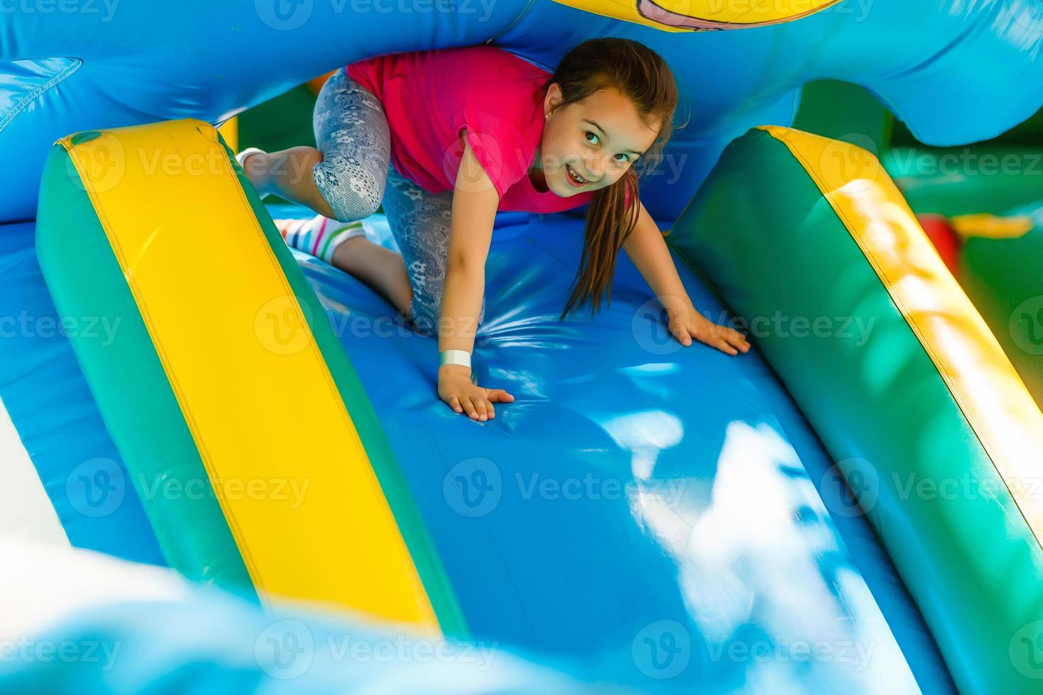 niña deslizándose por un tobogán inflable foto
