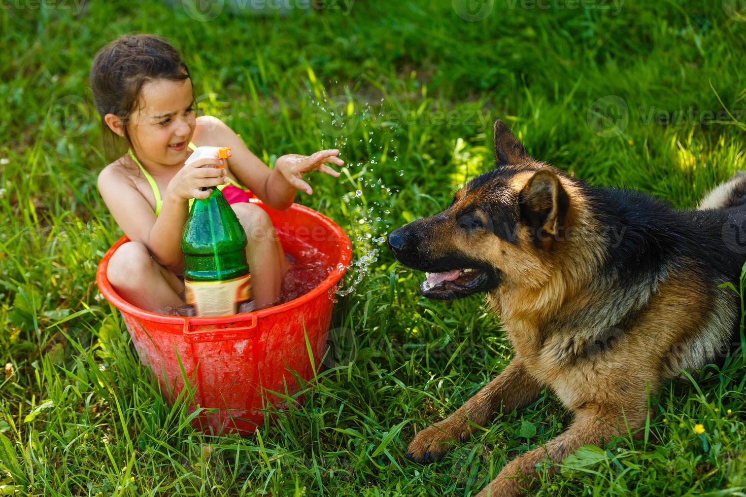 desarrollo infantil en armonía con la naturaleza. niñita hermosa jugando con agua y bañándose al aire libre en el césped en la higiene del tazón de lavado vintage, infancia feliz, concepto de naturaleza foto