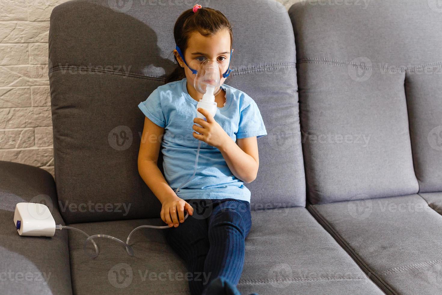 Little girl making inhalation with nebulizer at home. child asthma inhaler inhalation nebulizer steam sick cough concept Horizontal photo
