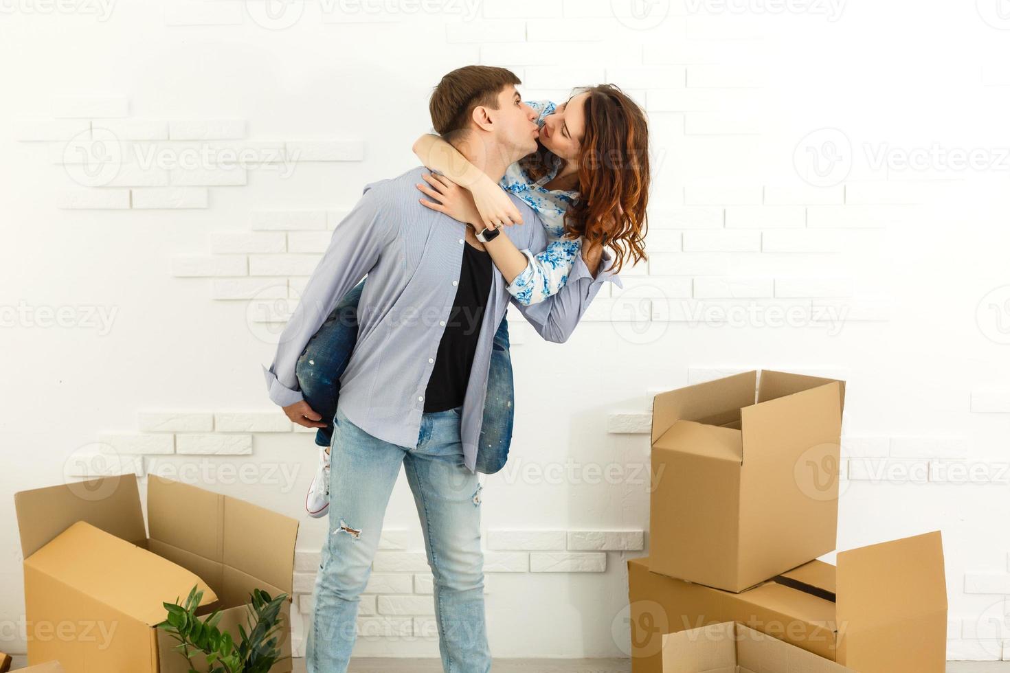 Smiling couple leaning on boxes in new home photo