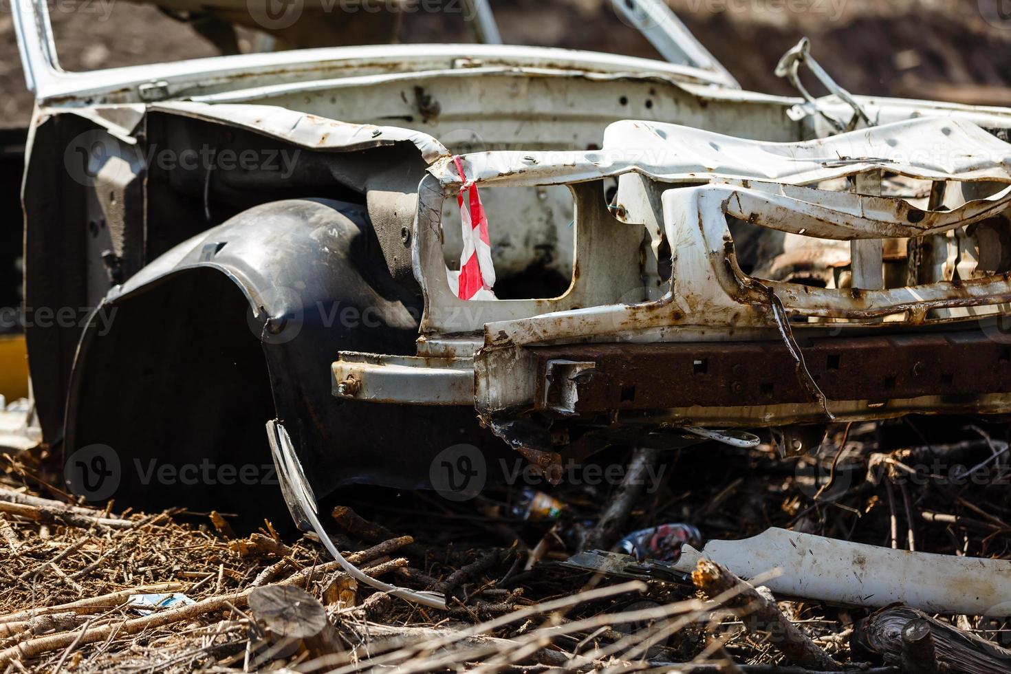 Broken car in a dump in the field photo