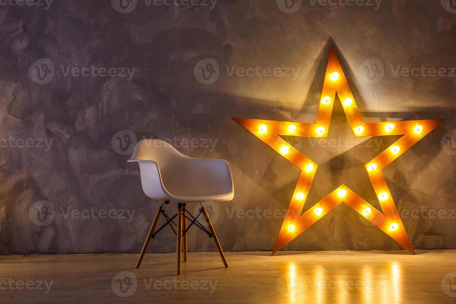 Star lamp on the background of an old wall, on the wooden floor, lights, lights, lights, glare. Exhibition star, light object, interior decor. Abstract dark background, night view, club photo