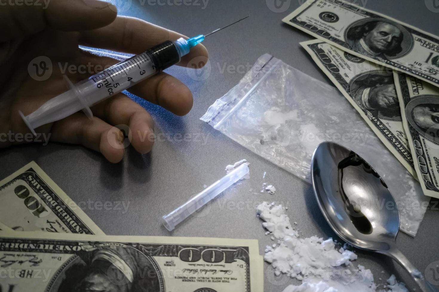 substance abuse, addiction, people and drug use concept - close up reaching to used syringes on ground photo