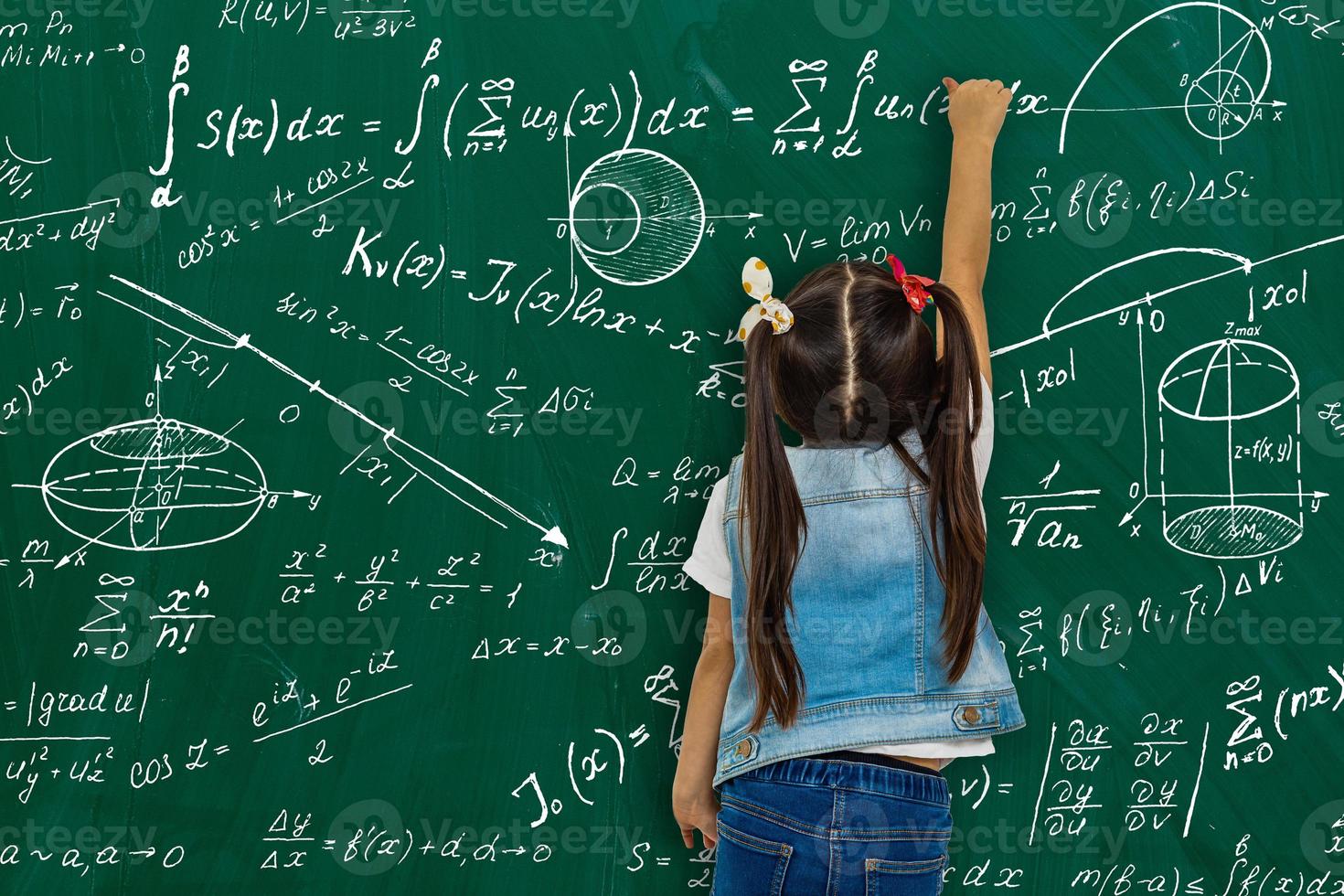Girl against big board with formulas, back view photo