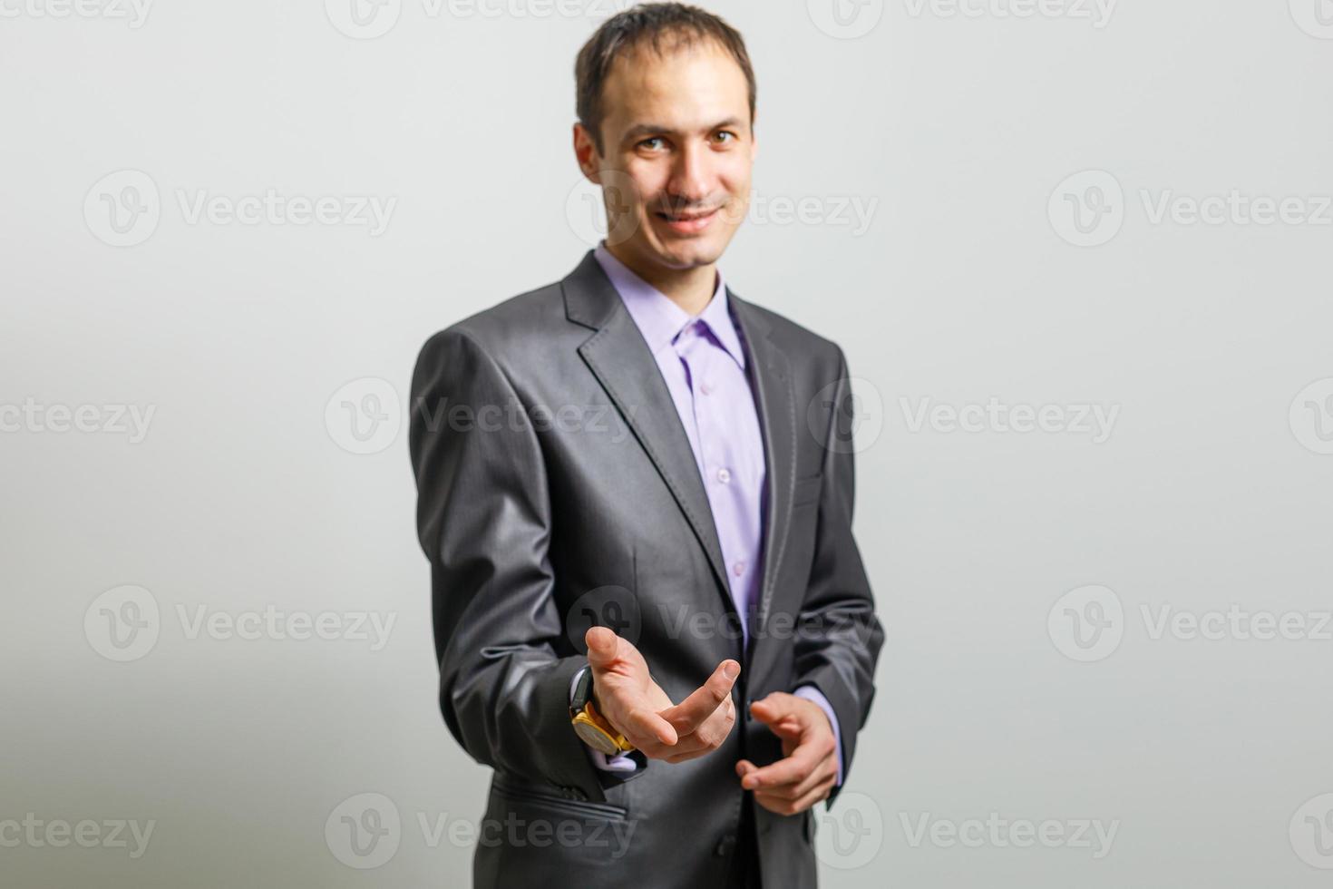 Cool businessman standing on grey background. photo