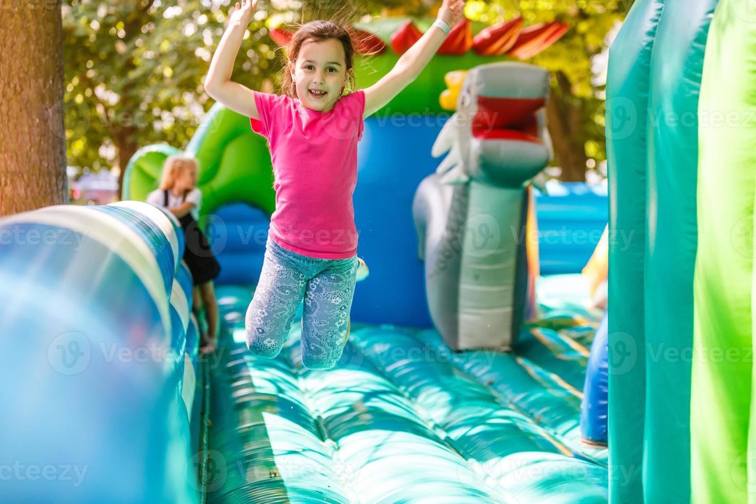 A cheerful child plays in an inflatable castle photo