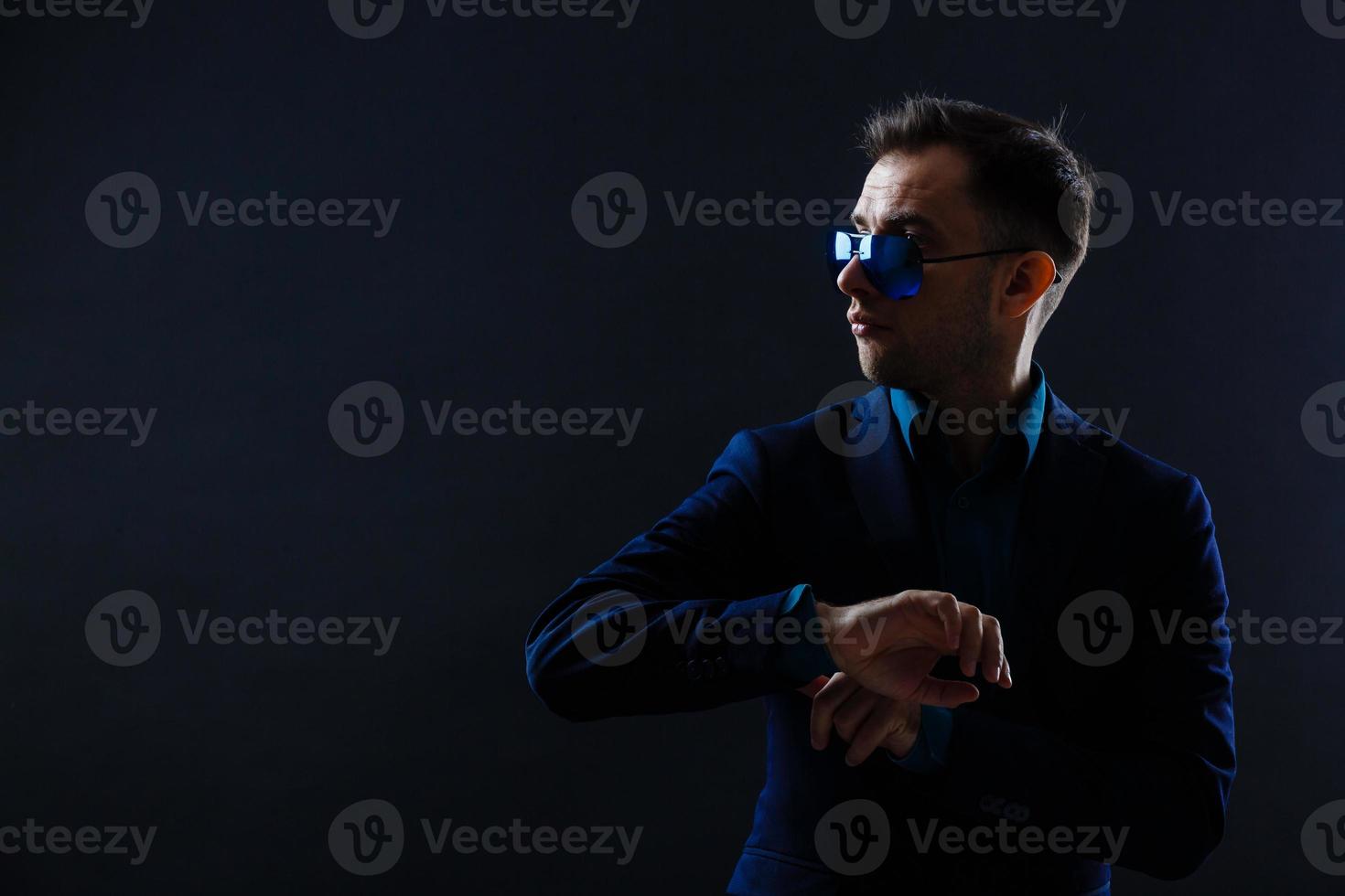 elegante joven guapo con gafas y observadores. retrato de moda de estudio. foto