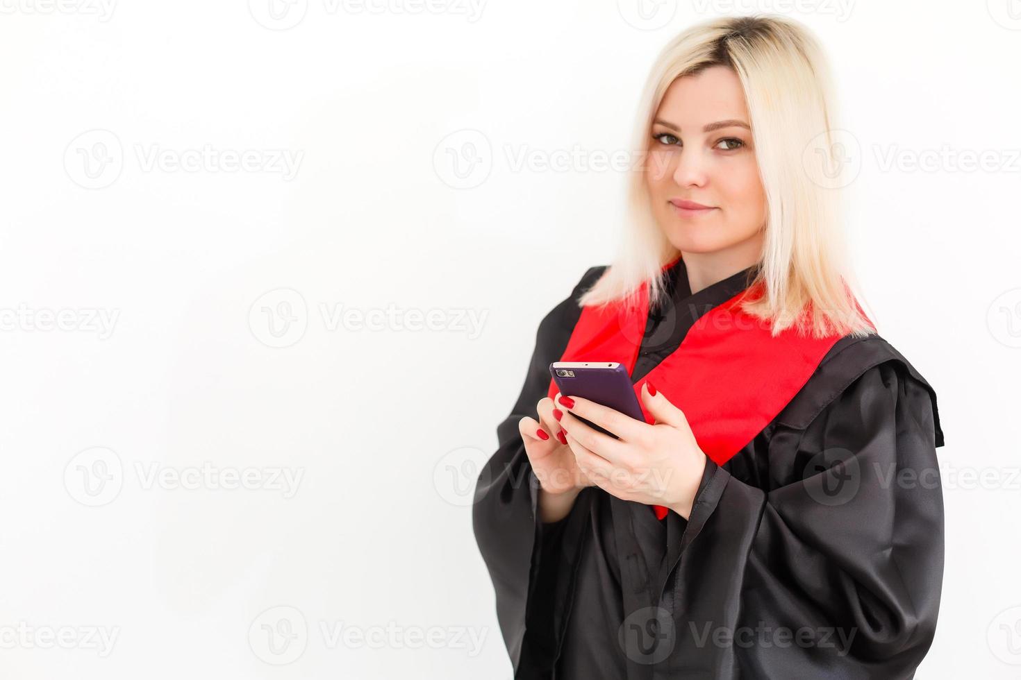 emocionada feliz estudiante graduada está de pie en el manto, sonriendo y mirando a la cámara foto