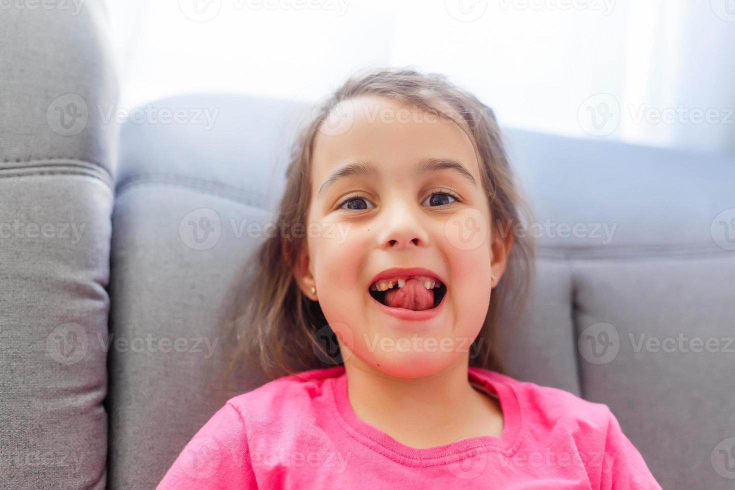 niña señalando sus dientes faltantes foto