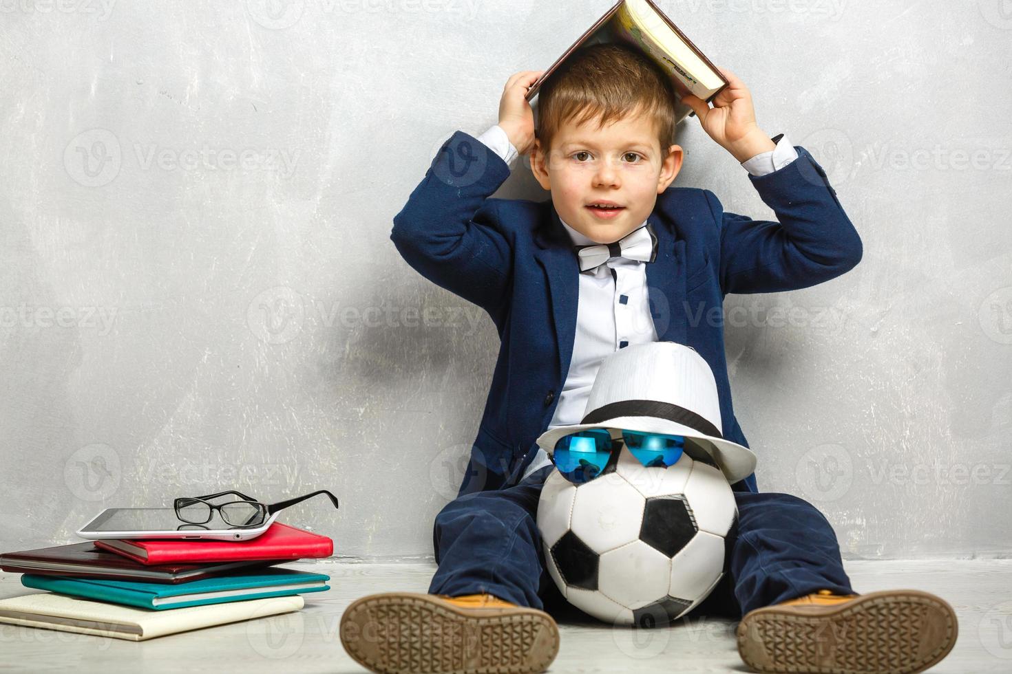 Elementary school student carrying notebooks over a gray background photo