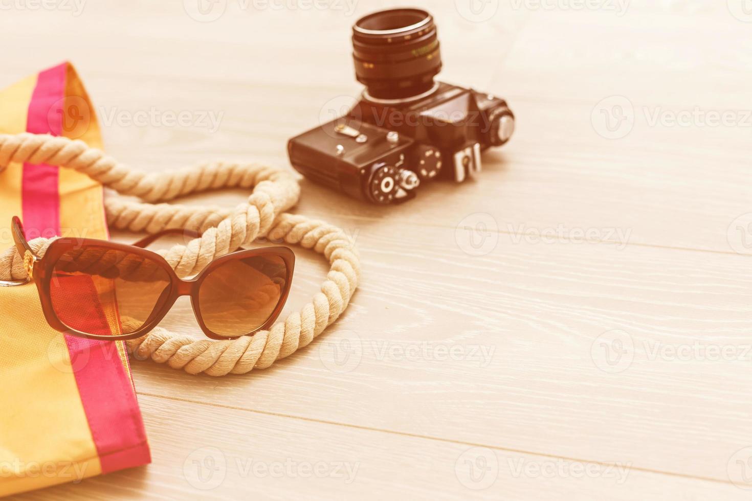 Packed suitcase of vacation items on wooden table, top view. photo