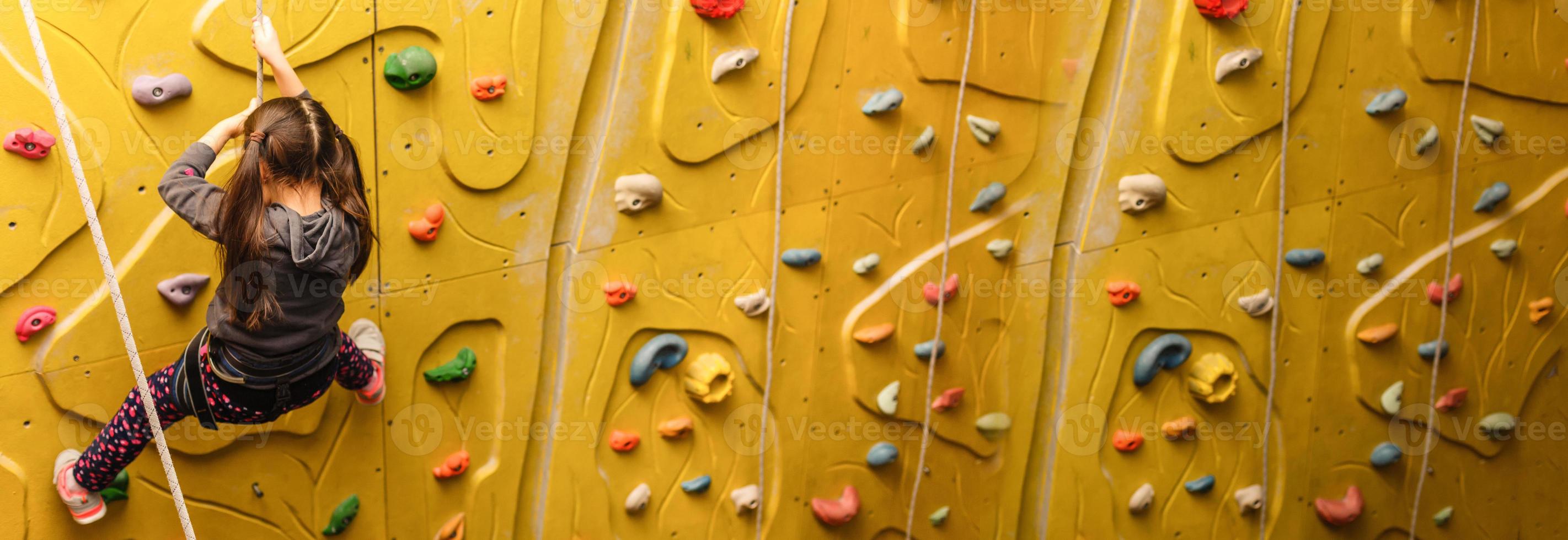 Little Girl Climbing Rock Wall photo