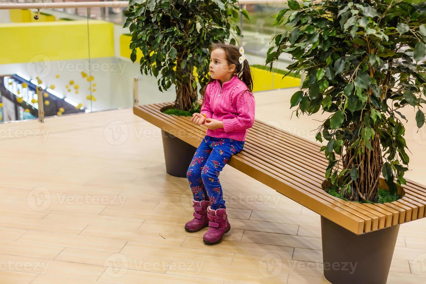 niña sola en el centro comercial, buscando a su madre. el niño se perdió en la tienda grande. foto