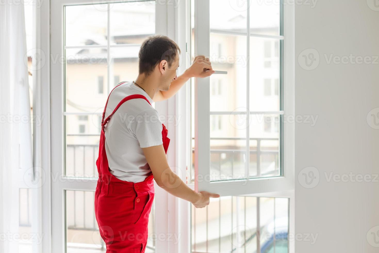 Construction worker installing new window in house photo