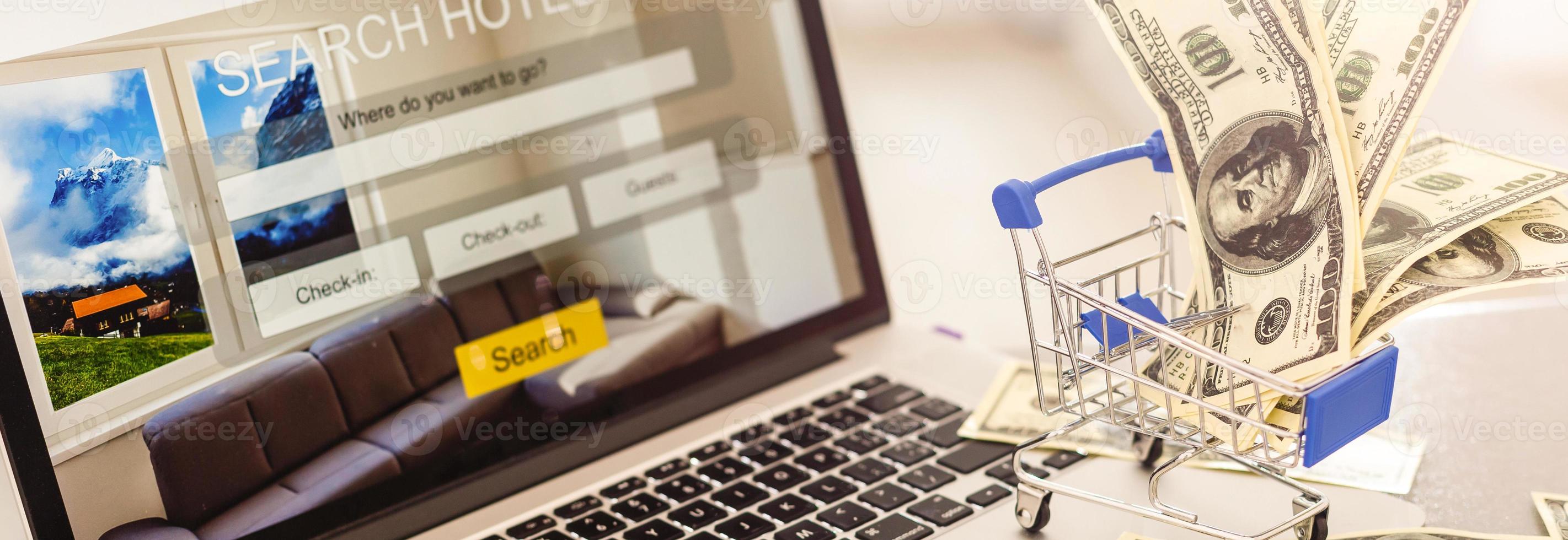 pequeño carrito de compras con computadora portátil para comprar concepto en línea. enfoque selectivo foto