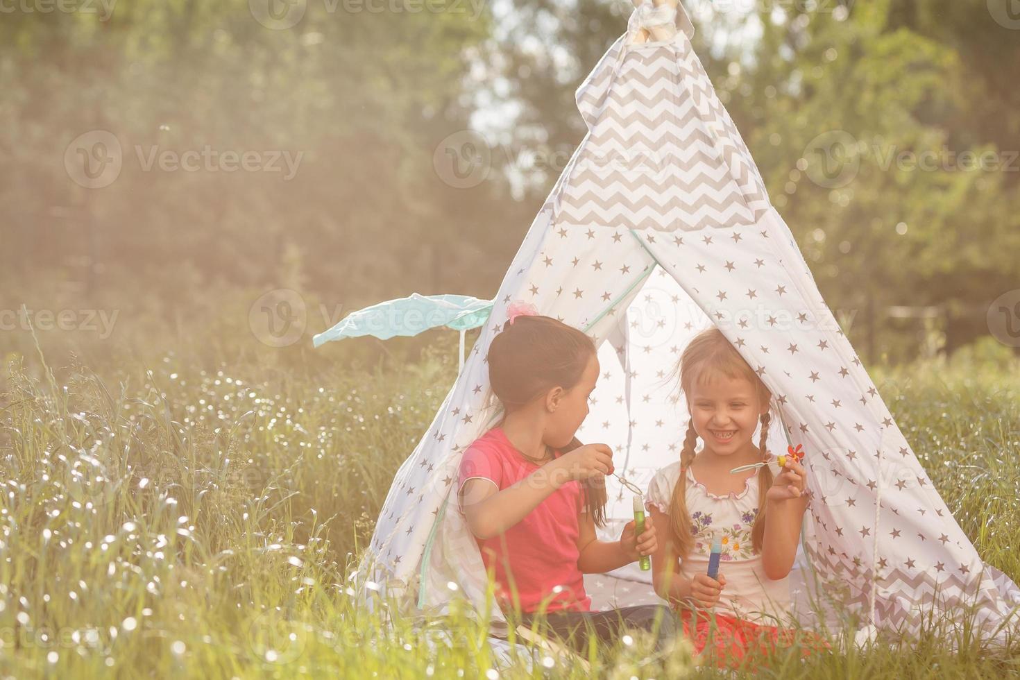 Adorable little girls having fun playing outdoors on summer day photo