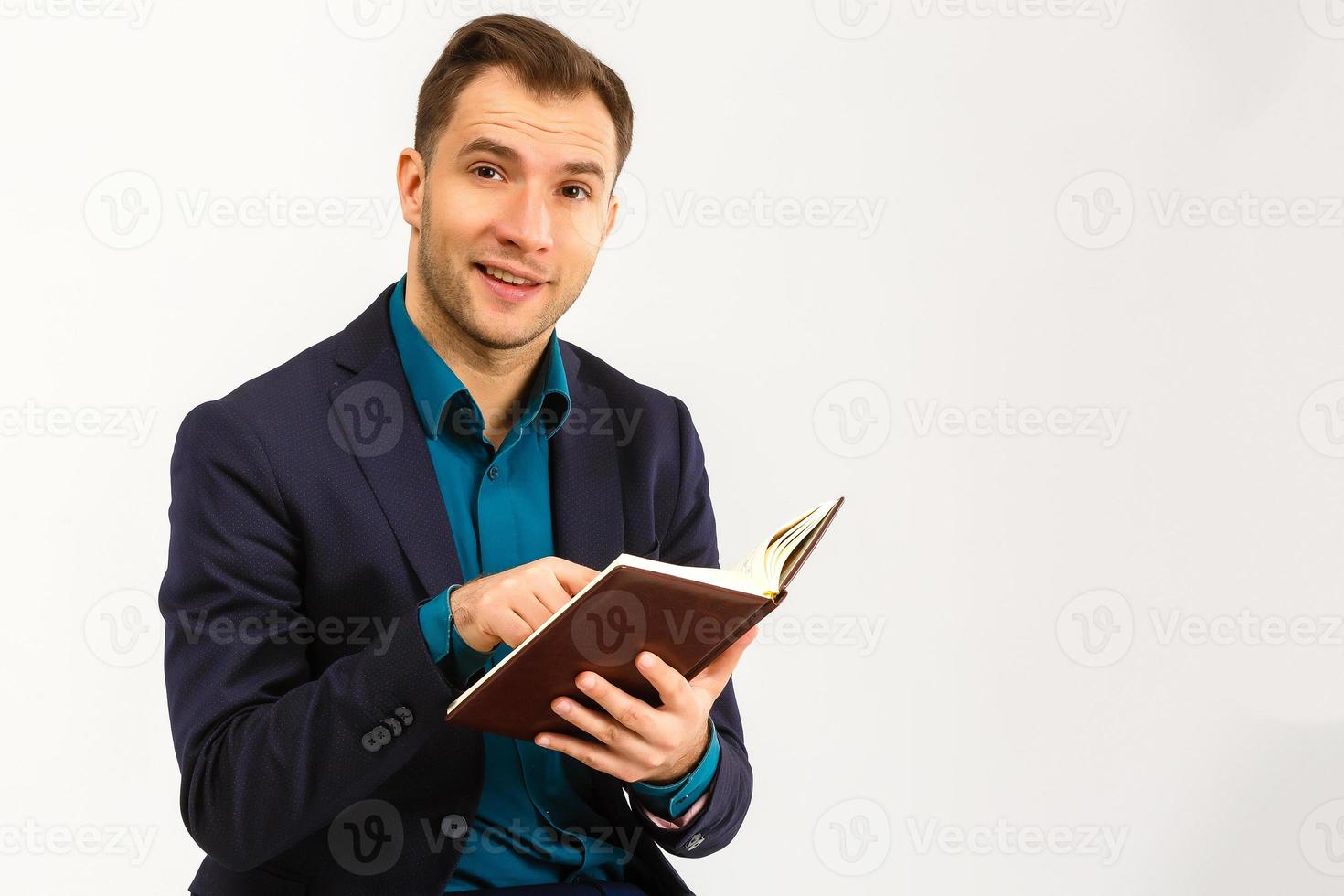 Portrait with copy space, empty place of stylish trendy teacher in shirt, jacket with stubble having three books in hands, looking at camera isolated on  background photo