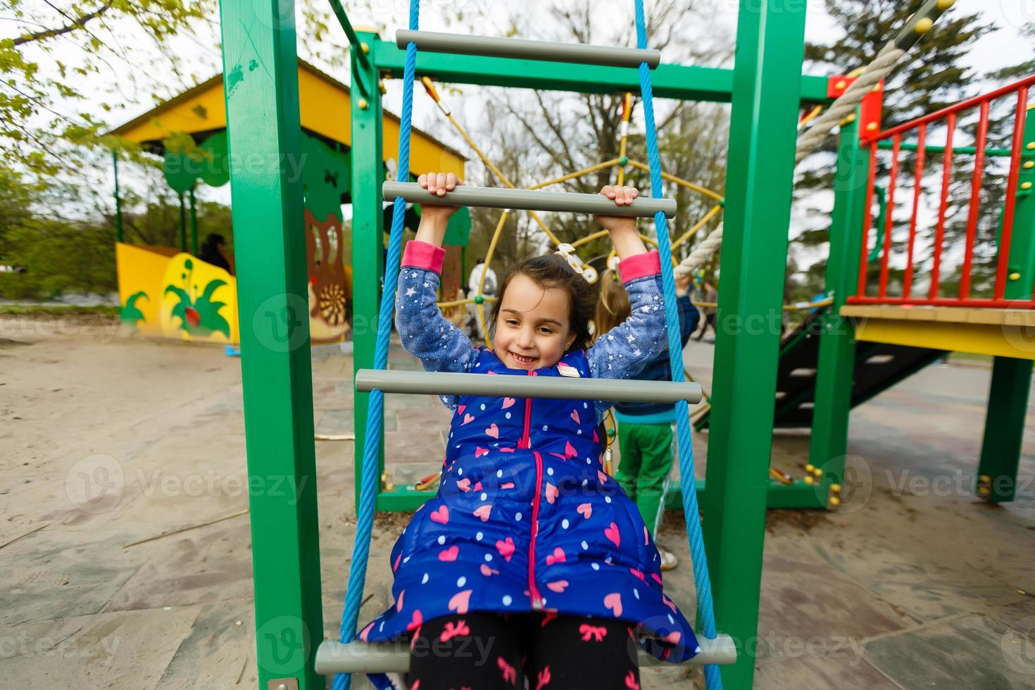 attractive little girl on outdoor playground equipment photo