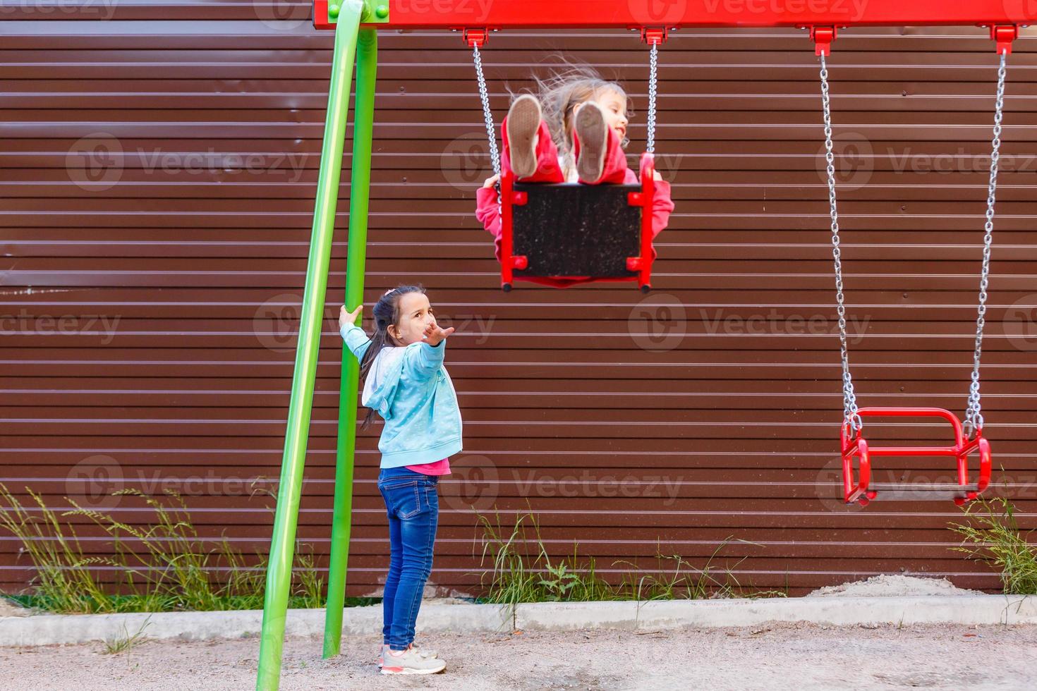 Young child on swing in playground outdoors photo