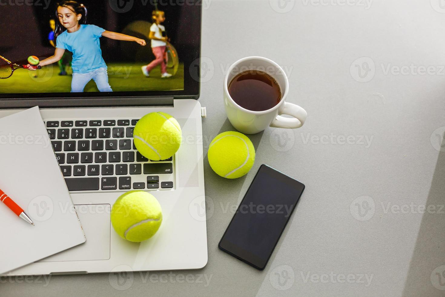 Sports tennis player with racket in blue costume. Woman atlete. Laptop on the table with design for bookmaker advertising photo