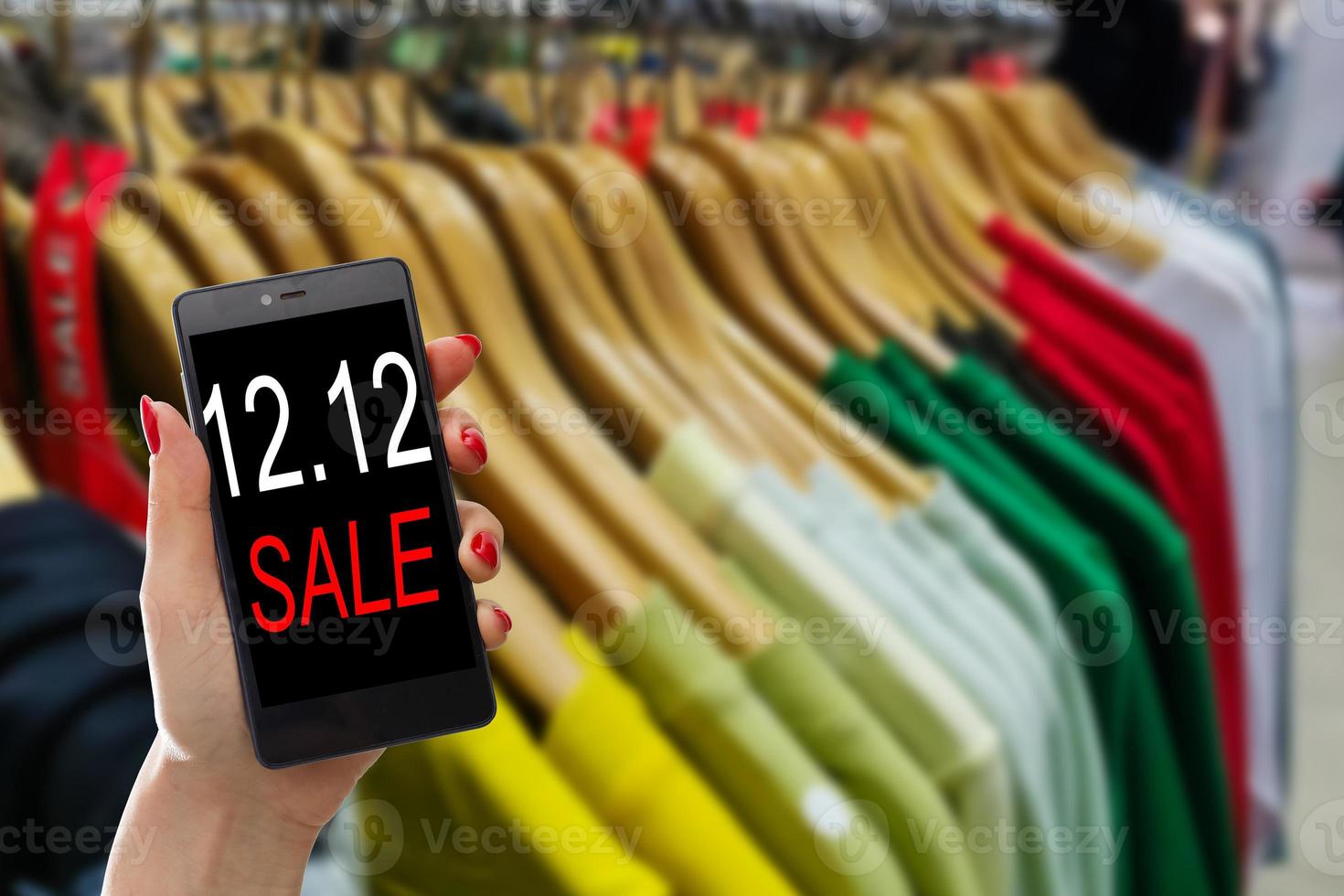 Woman hand holding mobile phone for 12.12 online shopping sale concept. photo