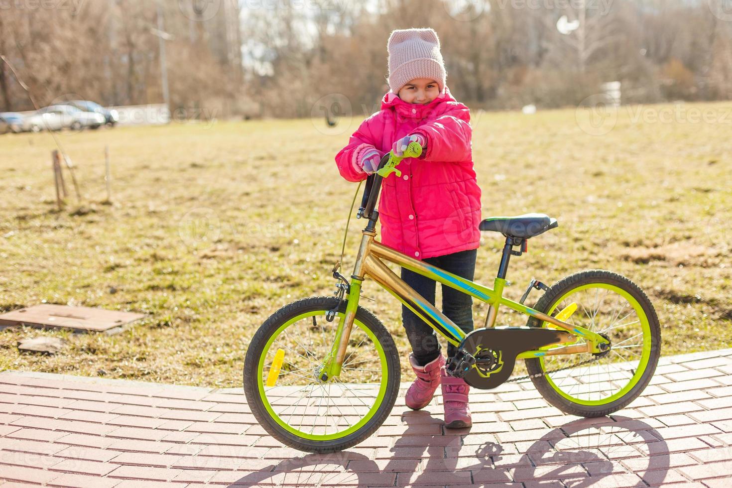 little girl riding bicycle in city park. photo