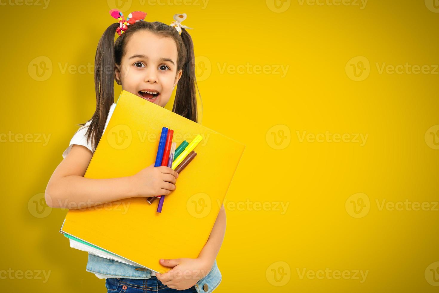 niña de la escuela de niño divertido niña sobre fondo amarillo foto