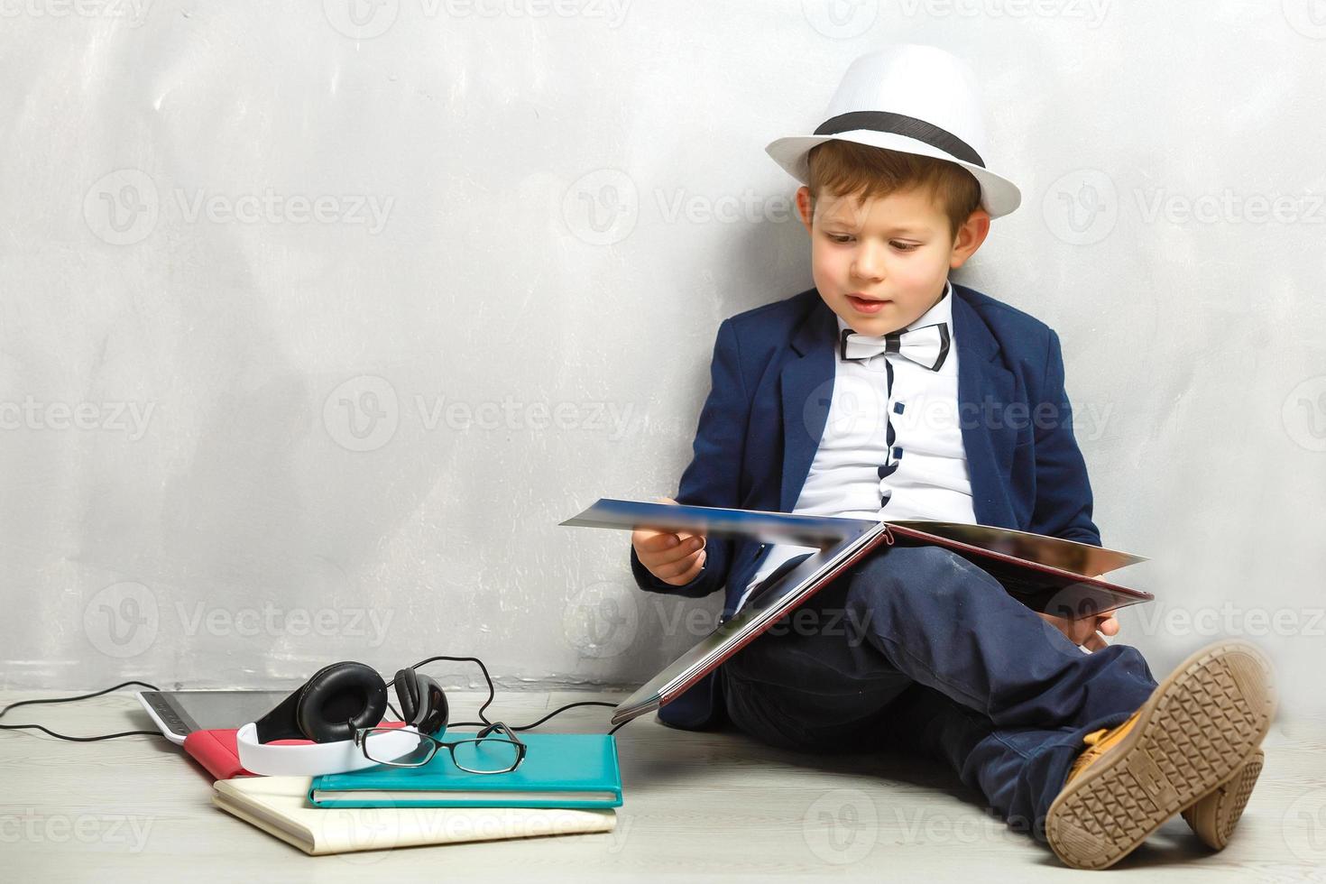 Happy curious kid little boy genius on gray background photo