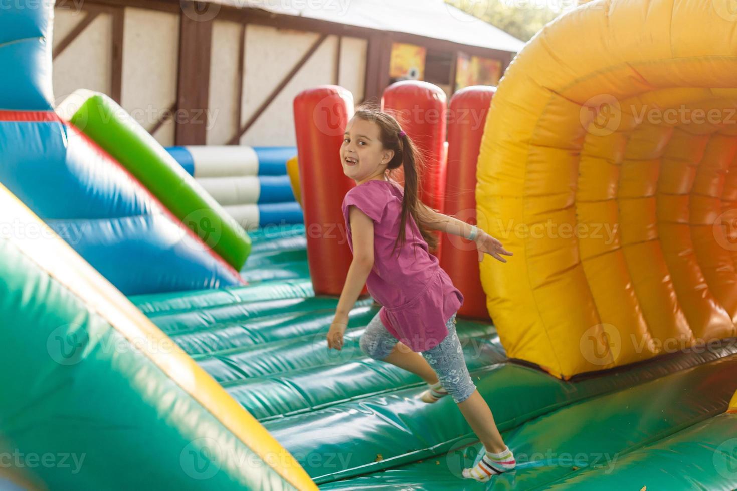 A cheerful child plays in an inflatable castle photo
