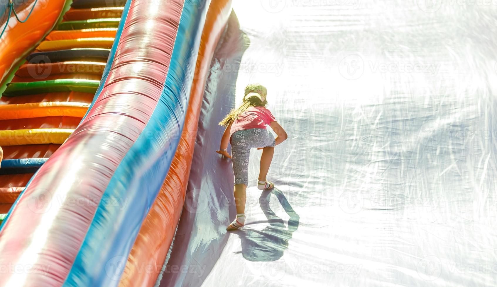 Joyful little girl playing on a trampoline photo