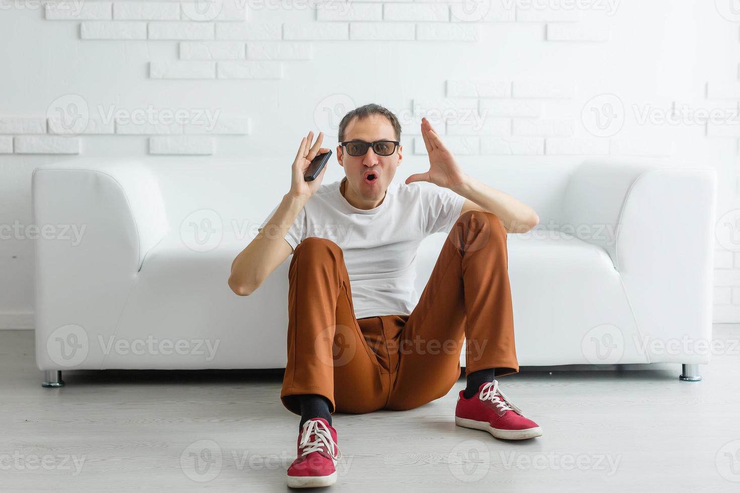 Young brunette white european man at home on quarantine on gray background. Coronavirus, illness, infection, quarantine photo
