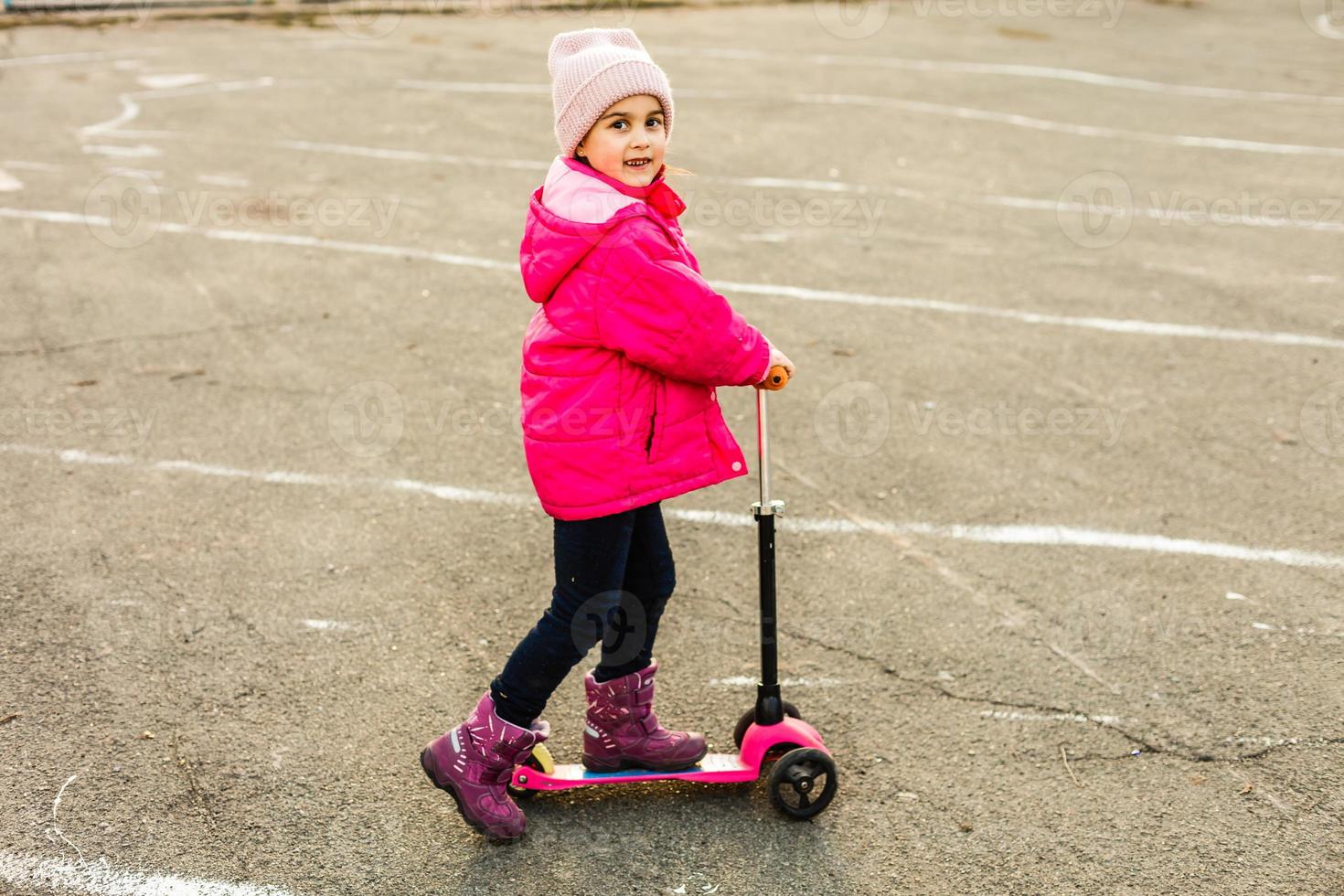 Child riding scooter. Kid on colorful kick board. Active outdoor fun for kids. Summer sports for preschool children. Little girl in spring park. photo