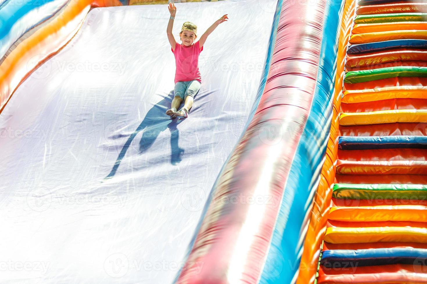 Little Girl sliding down an inflatable Slide photo