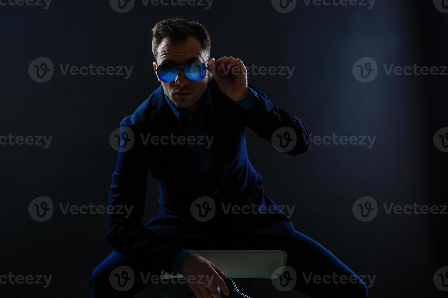 Happy smiling business man with crossed arms on black background photo