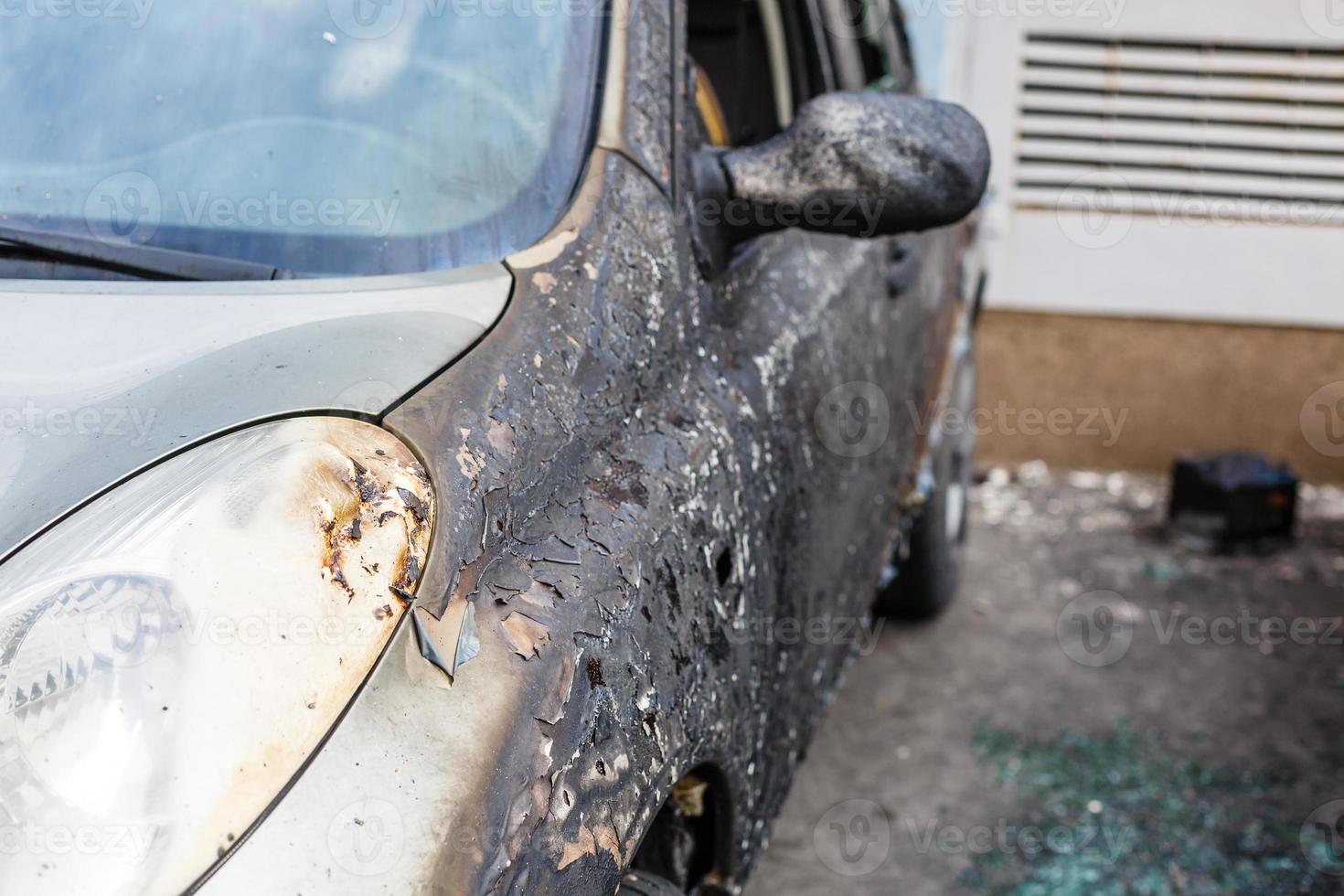 Burned car. set fire to cars in parking lot. Bandit wars, the destruction of the fire machine after the Molotov cocktail. Deformed fire machine. Consequences of car accident. damaged by arson photo