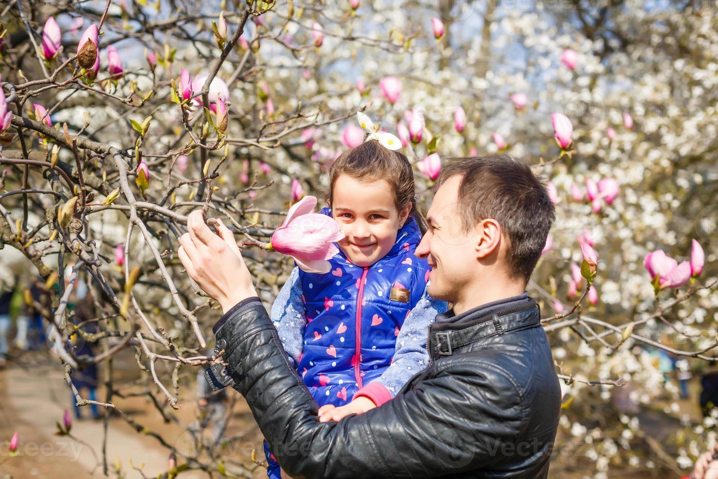 padre e hija juegan en un jardín - primavera foto