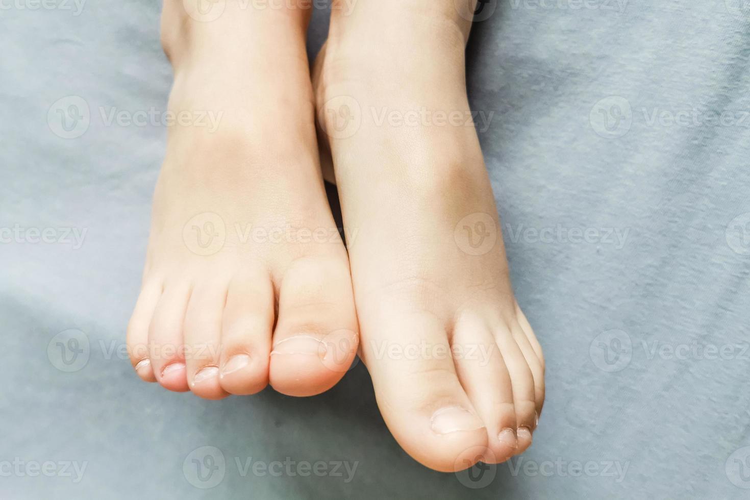 Children's bare feet. Child's bare feet on a gray bed photo