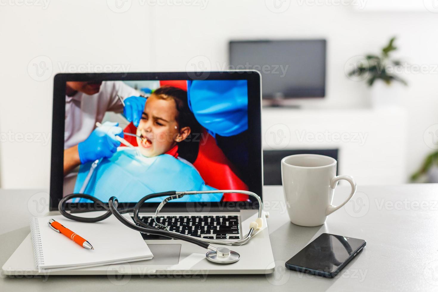 Workplace of doctor with laptop and stethoscope and notebook on white table top view shot photo