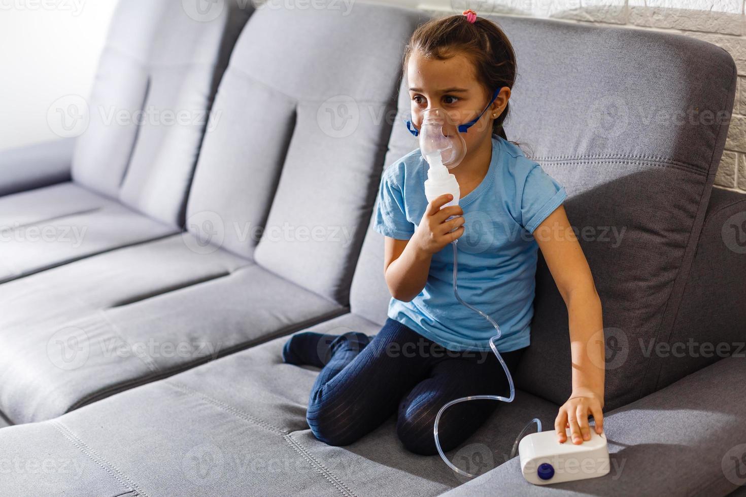 Little girl making inhalation with nebulizer at home. child asthma inhaler inhalation nebulizer steam sick cough concept Horizontal photo